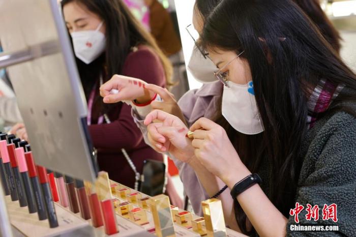 圖為女生正在體驗口紅產(chǎn)品。 殷立勤 攝