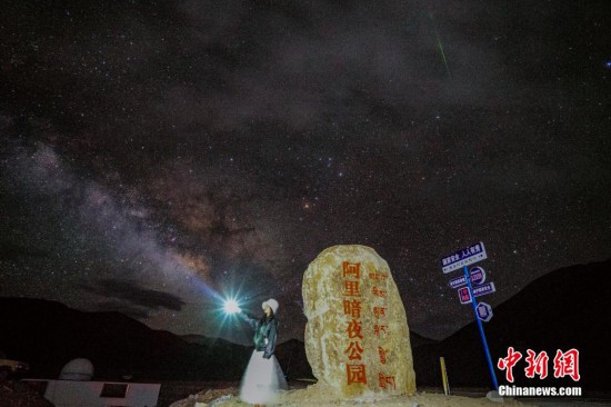 圖為6月20日晚，游客“打卡”西藏阿里暗夜公園，天上是銀河與流星（右上角）。曹枝清 攝