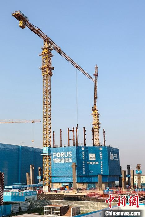 從完成頂層設(shè)計(jì)到如火如荼大規(guī)模建設(shè)，六年來(lái)，雄安新區(qū)如春天的竹子一般拔節(jié)生長(zhǎng)，這座承載千年大計(jì)的“未來(lái)之城”已雄姿初顯。從“一張白紙”開(kāi)始著墨，如今的雄安新區(qū)已是濃墨重彩的“山水畫(huà)”。<a target='_blank' href='/'>中新社</a>記者近日走訪了雄安新區(qū)多地，從“藍(lán)綠金”三色感受這座“未來(lái)之城”的巨大變化。圖為7月19日，河北雄安新區(qū)，中國(guó)中化總部基地項(xiàng)目施工現(xiàn)場(chǎng)。 <a target='_blank' href='/'>中新社</a>記者 易海菲 攝