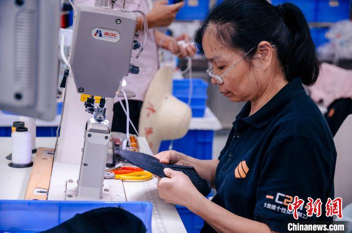 圖為員工在生產(chǎn)線工作?！±钅宪?攝