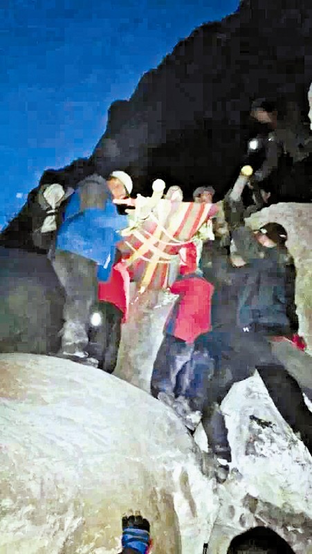 救援隊員用自制的簡易擔(dān)架抬傷者。