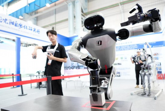 9月5日，在沈陽的2025全球工業(yè)互聯(lián)網(wǎng)大會的展覽區(qū)現(xiàn)場，中國科學(xué)院沈陽自動化研究所的機(jī)器人工程師在調(diào)試具身智能操作系統(tǒng)。新華社記者 李鋼 攝