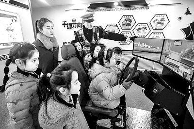 山東省榮成市公安局道路交通安全宣傳教育基地，交警帶領(lǐng)小學生現(xiàn)場體驗?zāi)M駕駛。新華社發(fā)