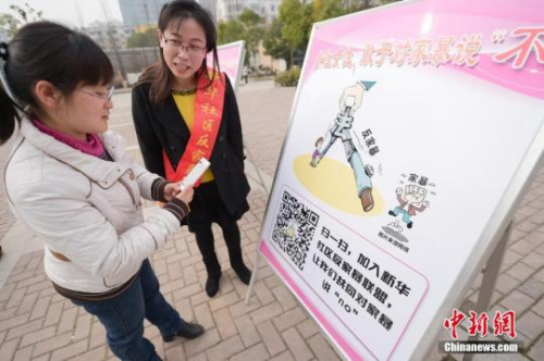 資料圖：今年3月8日，安徽合肥新華社區(qū)志愿者夏一瓊(右)向市民普及反家暴相關(guān)法律知識(shí)。鐘欣 攝