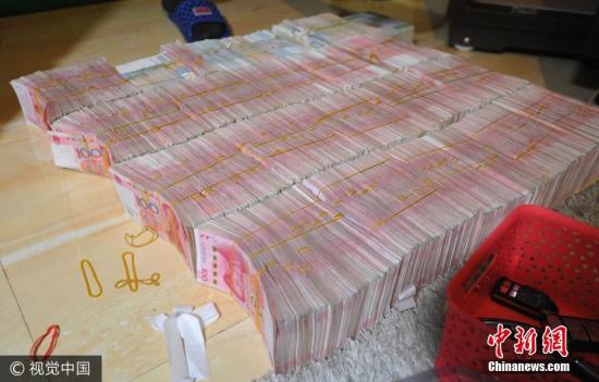 廣西南寧警方8月21日通報，當?shù)亟粘晒善粕姘附痤~15.19億元人民幣的特大傳銷案件。圖為當場繳獲的成捆現(xiàn)金。圖片來源：視覺中國