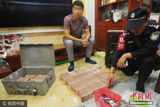 廣西南寧警方8月21日通報，當?shù)亟粘晒善粕姘附痤~15.19億元人民幣的特大傳銷案件。圖為當場繳獲的成捆現(xiàn)金。 圖片來源：視覺中國