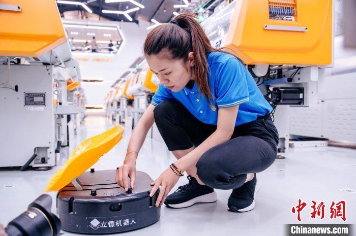 圖為員工在調(diào)試AGV搬運機器人?！±钅宪?攝