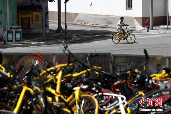 上?，F(xiàn)共享單車(chē)“墳?zāi)埂?堆積如山場(chǎng)面壯觀。 張亨偉 攝